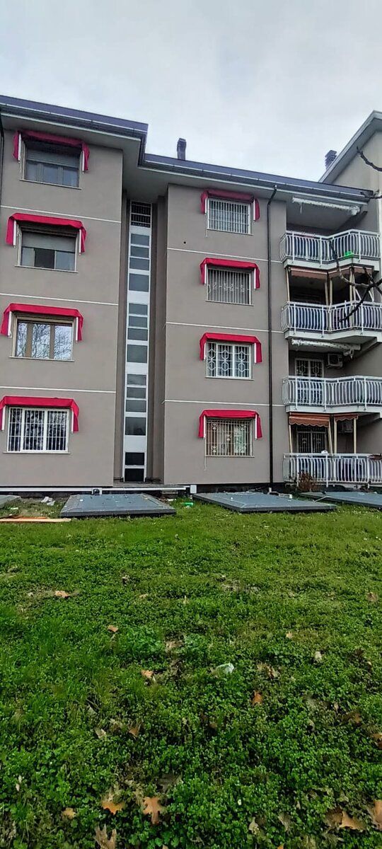 Prospetto della palazzina a lavori conclusi, con il prato davanti.